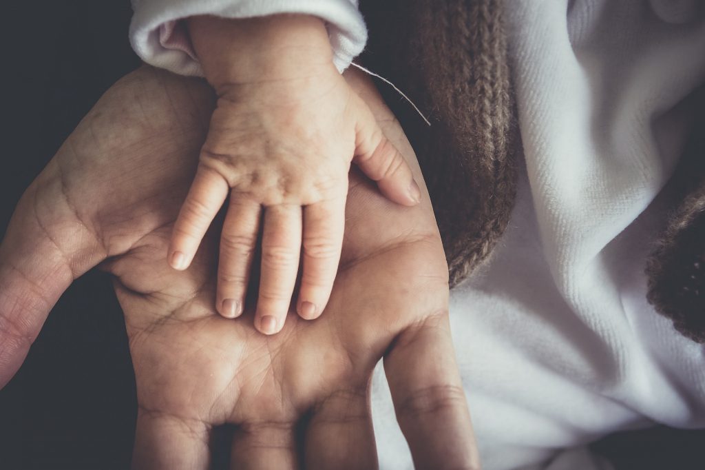 baby hand on top of mother's hand